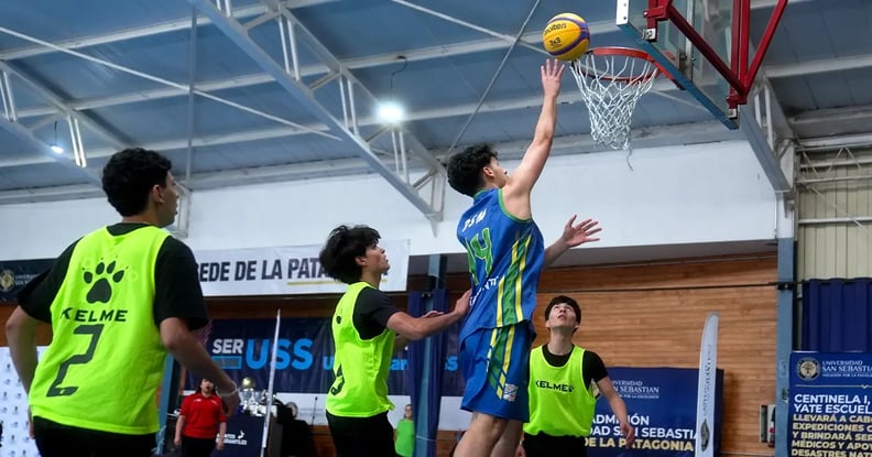 jugador clavando el balón en el aro de baloncesto